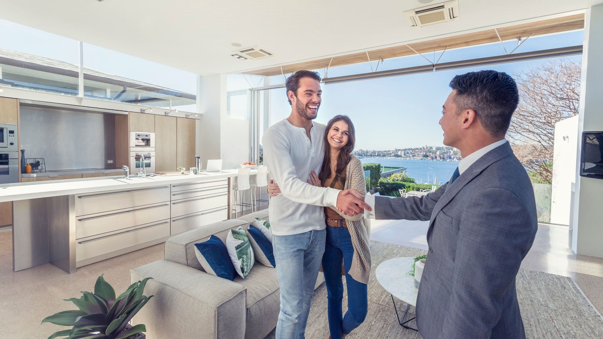 couple with property valuer shaking hands