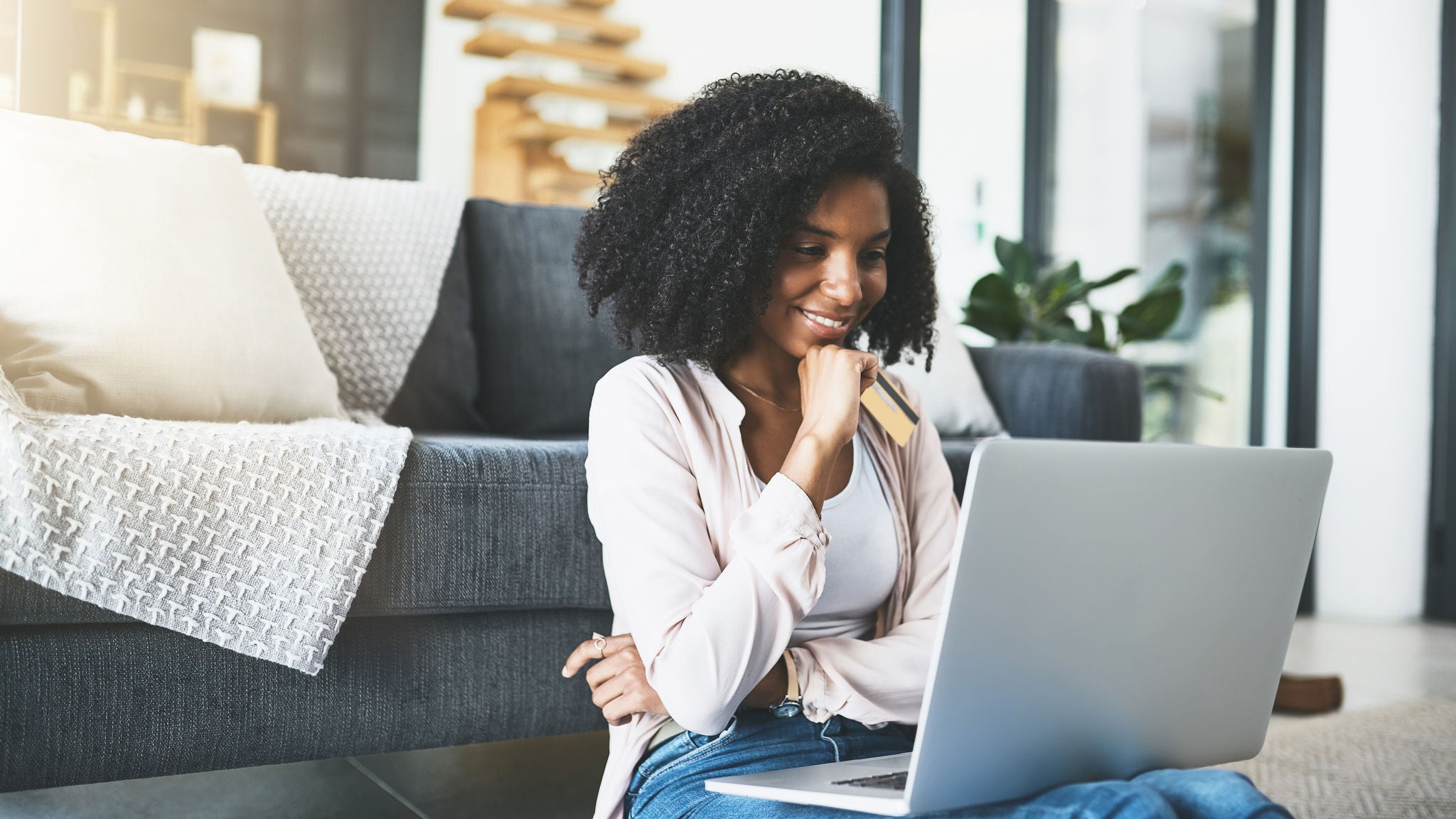 a woman in front of a laptop thinking if it's safe to enter her card details